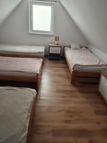a room with three beds and a window at Domek u Ewy w Spychowie in Spychowo