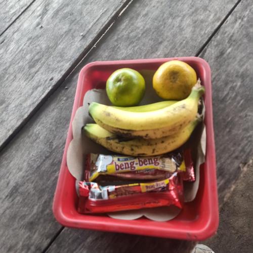 a red basket with bananas and apples and chips at Above the Clouds Camp in Kintamani