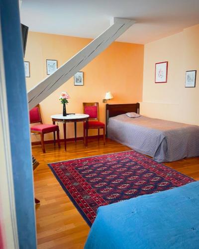 a bedroom with two beds and a table with chairs at Hôtel Restaurant Chez Henriette in Phalsbourg