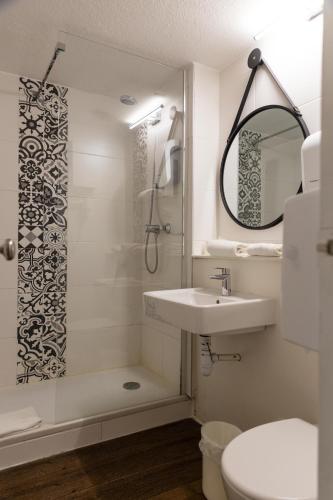 a bathroom with a sink and a shower at The Originals City, Hôtel Cap Sud, Avignon in Avignon