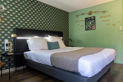 a bedroom with a large bed with green walls at The Originals City, Hôtel Cap Sud, Avignon in Avignon