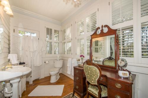 een badkamer met een wastafel, een toilet en een spiegel bij Oak Hill On Love Lane Bed and Breakfast Inn in Waynesville