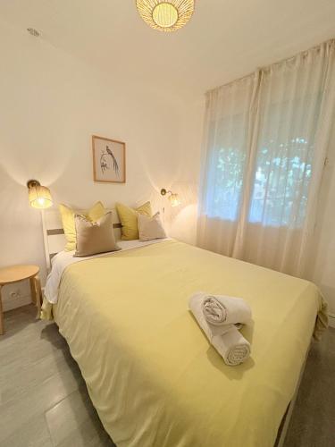 a bedroom with a large white bed with towels on it at La lavande in Arles