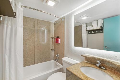 a bathroom with a sink and a toilet and a shower at SureStay Studio by Best Western Virginia Beach Oceanfront in Virginia Beach