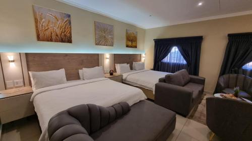 a hotel room with two beds and a couch at Luxury Fairland Fully Serviced Cottages in Johannesburg
