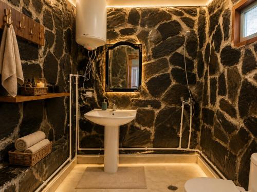 a bathroom with a sink and a stone wall at Stone House marexi in Adishi