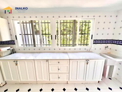 a kitchen with white cabinets and a window at Villa Marina - Inalko in Alcossebre