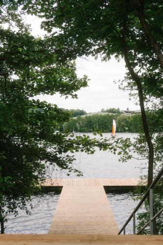a wooden dock on a lake with a sail boat at Raduńskie Zacisze in Chmielno