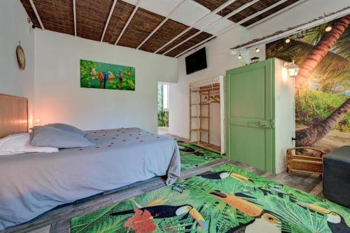 a bedroom with a bed and a green cabinet at lemasrocamour in Roquemaure