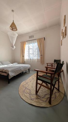 a bedroom with a bed and a table and a desk at Nomads nest safari house in Arusha