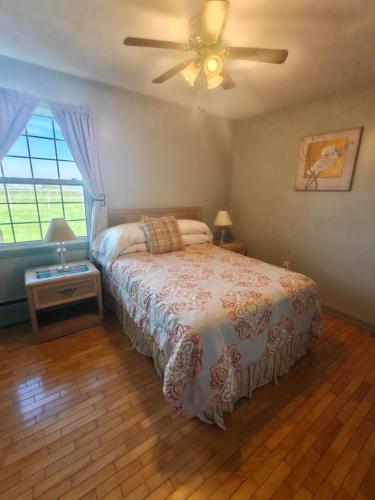 a bedroom with a bed and a ceiling fan at Dreamweavers Cottages and Vacation Homes in Rustico