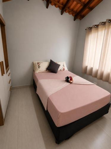 a bedroom with a large bed with pink sheets at Canto Sereno Refúgio entre Praias e Ilhas in Paraty
