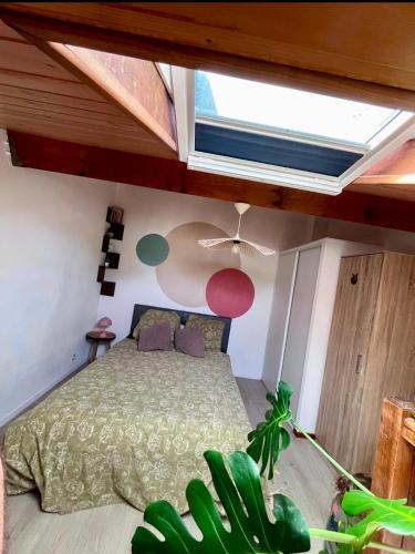 a bedroom with a bed under a roof at La Parenthèse Landaise Duplex rénové avec jardin & piscine in Saint-Julien-en-Born