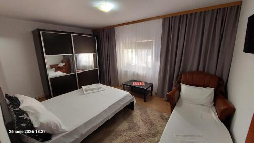 a hotel room with two beds and a chair at Casa Vio parter in Eforie Nord