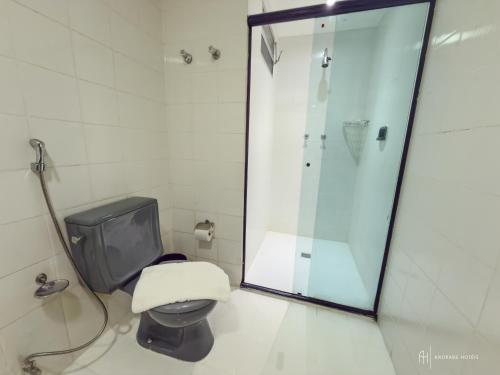 a bathroom with a toilet and a glass shower at Rede Andrade Aquarius in Porto Velho