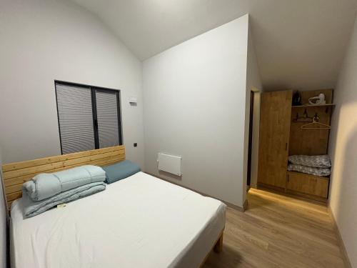 a bedroom with a white bed and a window at DreamHouse in Cholpon-Ata