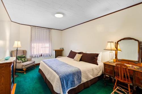 a bedroom with a bed and a desk and a mirror at Ryan Hotel in Wallace