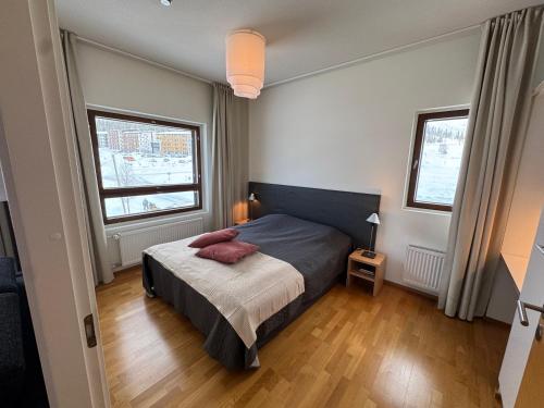 a bedroom with a bed and two windows at Ylläs Chalets 7305 in Ylläs