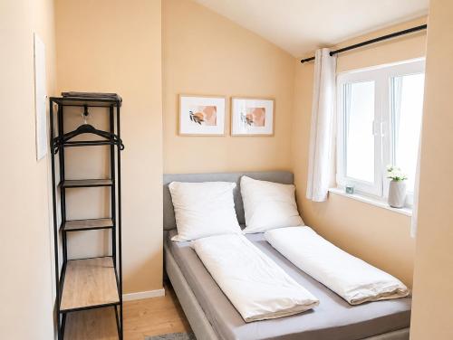 a room with a couch with pillows and a shelf at MeinZuhause Apartmente NG in Bad Pyrmont