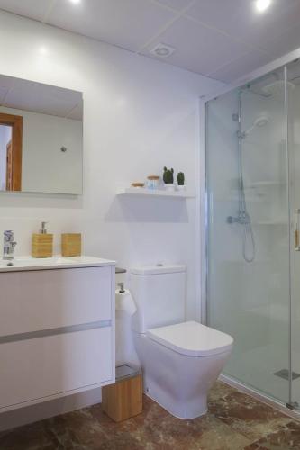 a white bathroom with a toilet and a shower at Purísima Vivienda Turística in Córdoba