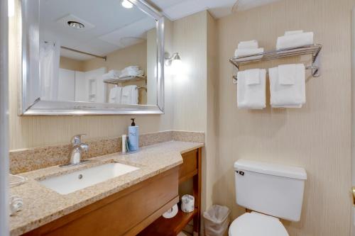 a bathroom with a sink and a toilet and a mirror at The Bay Resort in Dewey Beach