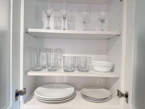 a cupboard filled with glasses and plates and bowls at Quiet retreat near Coconut Grove free parking in Miami