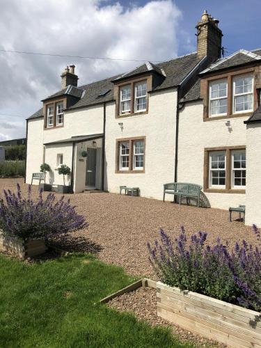 a house with a bench in front of it at Kates Cottages Kinnighallen in Spott