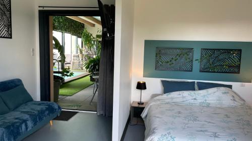 a bedroom with a bed and a couch next to a door at Desirad in La Clisse
