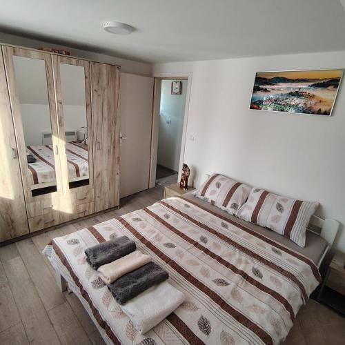 a bedroom with a large bed and a mirror at Kuca za Odmor ISKRA in Mokra Gora