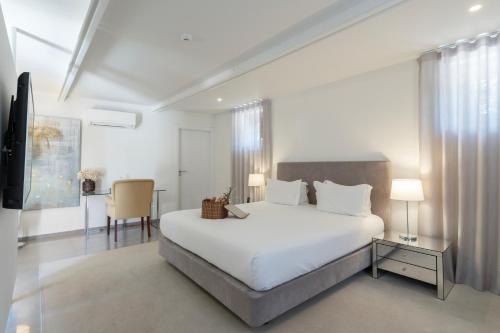 a white bedroom with a large bed and a desk at Paço do Bispo Boutique House in Sintra