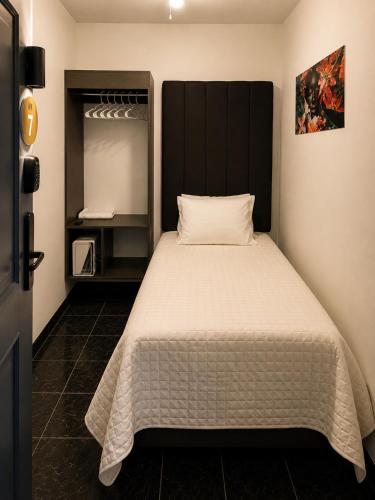 a bedroom with a bed with a black headboard at Barrio Inn Padre Mier Hostal & Suites in Monterrey