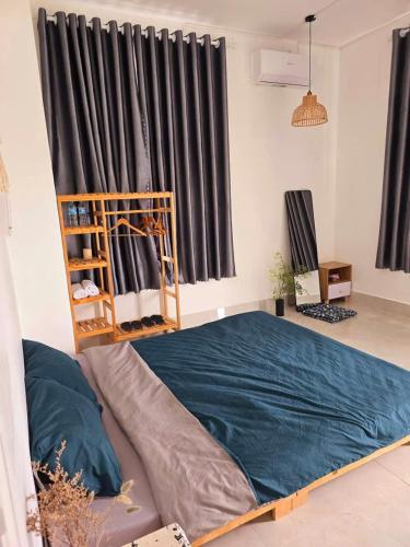 a bedroom with a bed with a blue blanket at Nhi Homestay Phòng đơn 1 in Rạch Giá