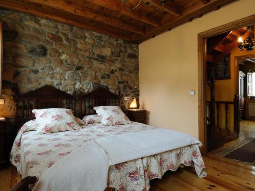 帕哈雷斯的住宿－Casa Guela，一间卧室配有一张石墙床