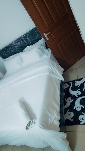 a bed with white sheets and pillows on it at Kerry Luxury Stays in Athi River