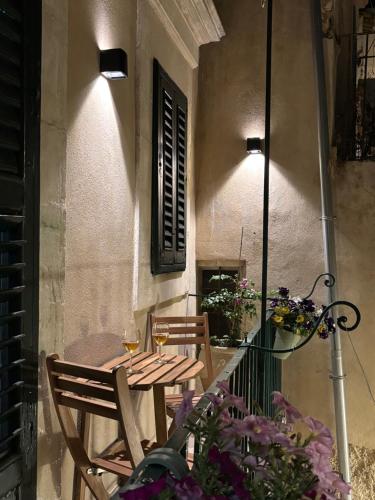 a table and chairs on a balcony with flowers at MiLù Sicily House in Modica