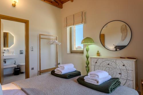 a bedroom with a bed with towels on it at The Olive Grove Kardamyli in Kardamyli