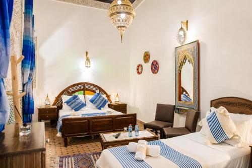 a hotel room with two beds and a mirror at Riad Nassim Fez in Fez