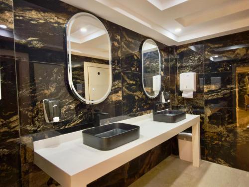 a bathroom with two sinks and two mirrors at Palace rif zicht in Nador