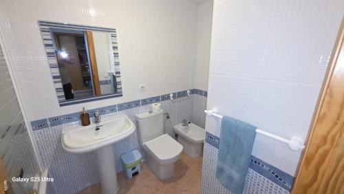 a bathroom with a sink and a toilet and a mirror at Miramar Playa confortable apartament in Miramar
