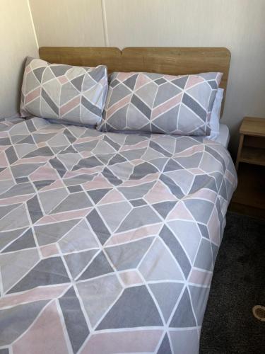 a bedroom with a bed with pink and white sheets and pillows at Eyemouth getaway in Eyemouth