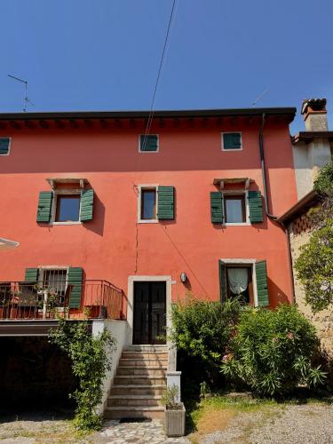 a red house with a staircase in front of it at Casa Olivia Bardolino - Garda Lake in Bardolino