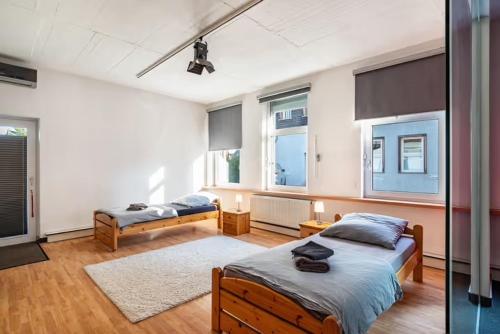a bedroom with two beds and two windows at Loftwohnung 140 qm mit Parkplatz, Wlan, 2 Schlafzimmer, Terrasse , Wäscheservice in Groß-Umstadt