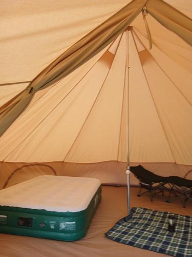 a tent with a bed and a chair in it at Hal`s at Killynick in Killyhevlin