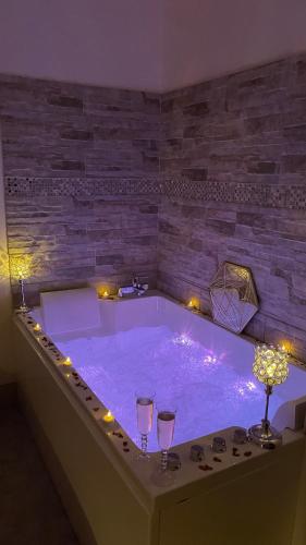 a jacuzzi tub with two wine glasses in it at Desirad in La Clisse