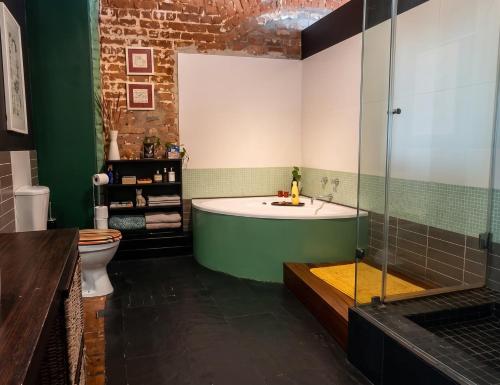 a bathroom with a bath tub and a toilet at Cat-themed East City Loft Apartment in Cape Town