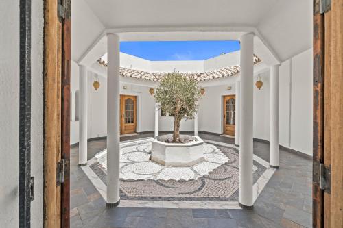 an open door to a courtyard with a tree in a planter at Vilamoura 4-Bedroom Private Pool Villa in Vilamoura