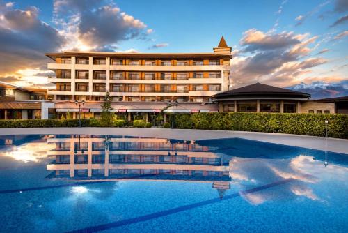 a hotel with a pool in front of a building at Hotel Sevtopolis Medical & SPA in Pavel Banya