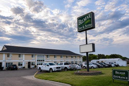 a sign for a hotel with cars parked in a parking lot at Bilmar Inn & Suites Dell Rapids Near Sioux Falls in Dell Rapids