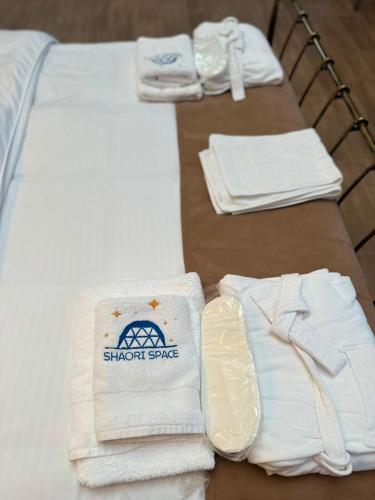 a table topped with white towels and a bed at Shaori Space - შაორი სფეისი in Nikortsminda