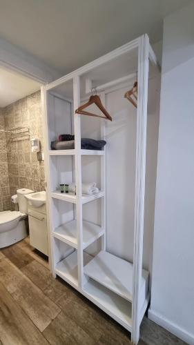 a white cabinet in a bathroom with a toilet at hostal olozaga in Alicante